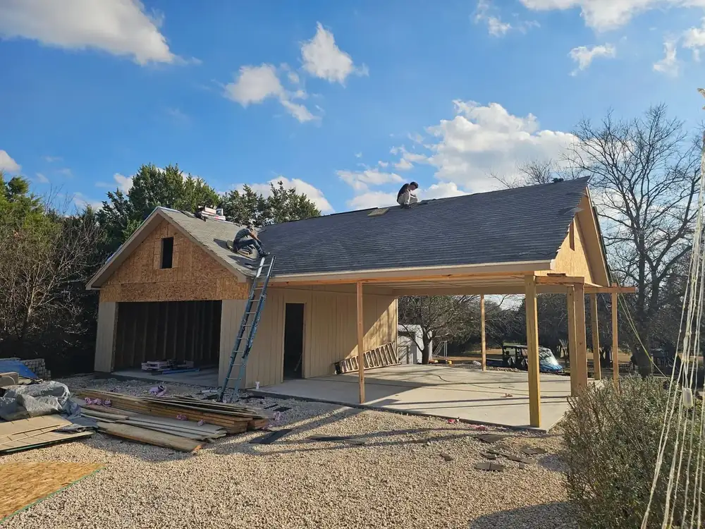 The garage and carport under construction, wood framed with roof decking going on